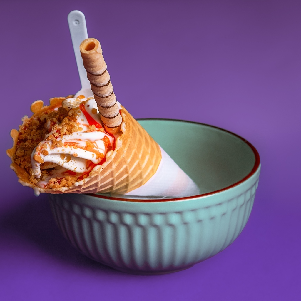 Мороженое рожок с трубочкой на фиолетовом фоне