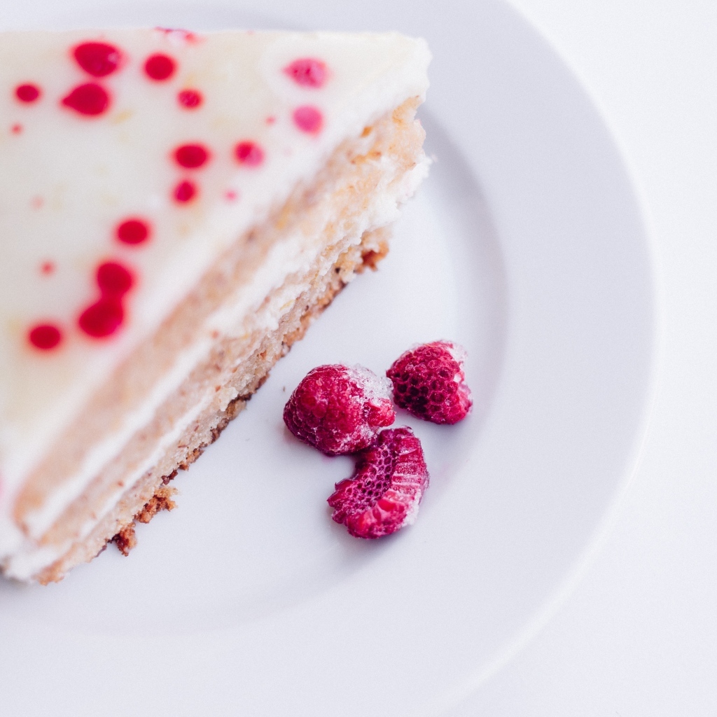 Пирог с ягодами малины на белой тарелке