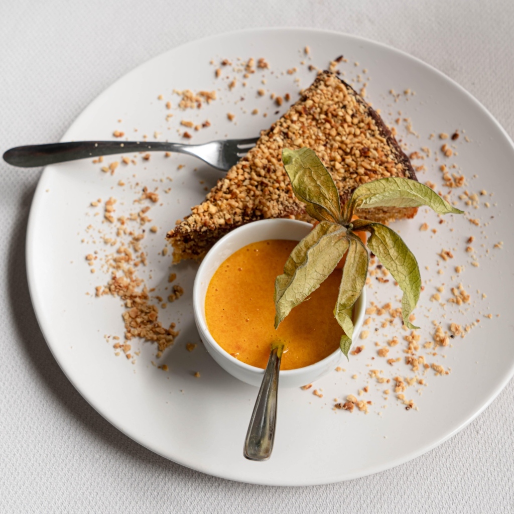 Кусок торта на белой тарелке с соком 