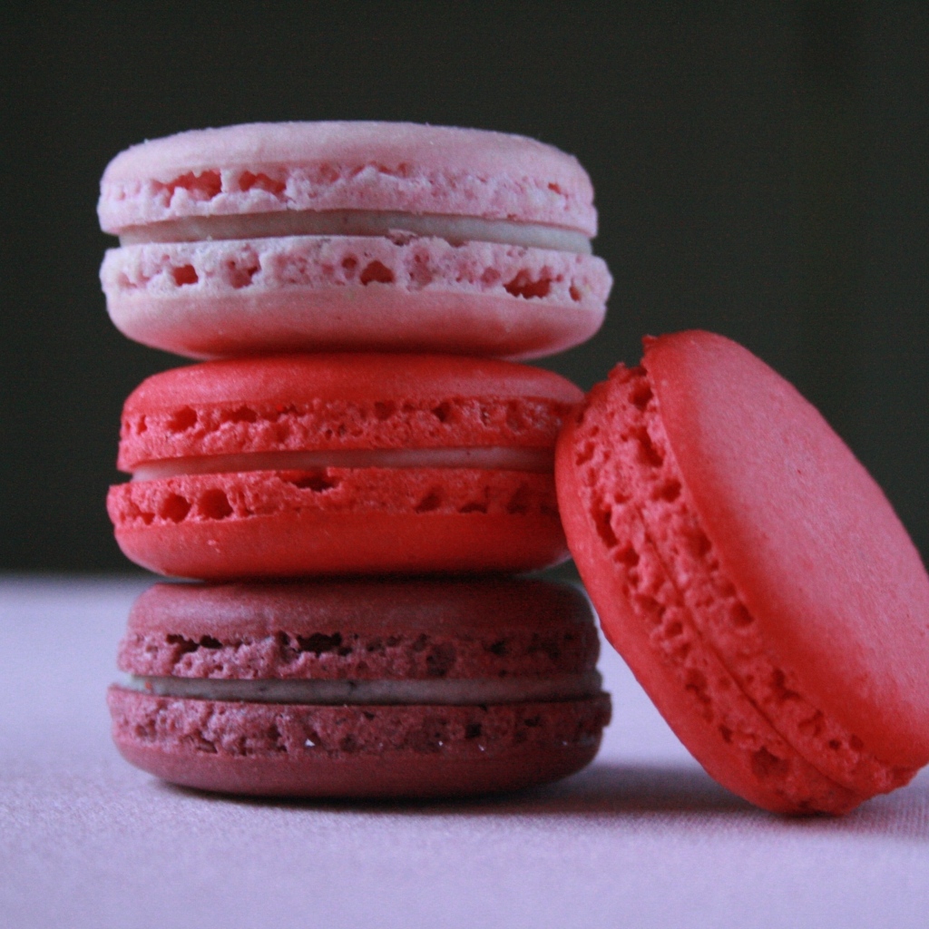 Розовый десерт макарон на столе 