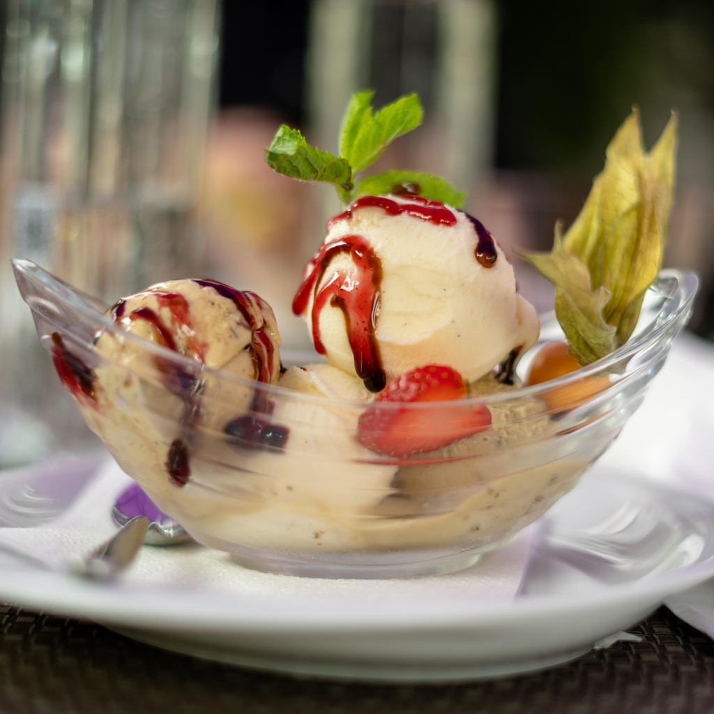 Шарики фруктового мороженого в стеклянной пиале на столе