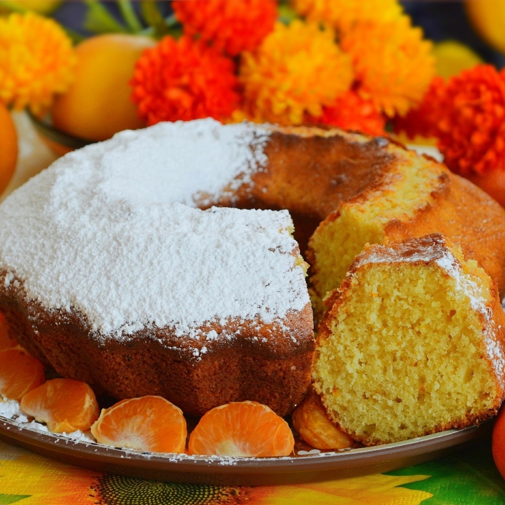 Сладкий пирог на столе с мандаринами и апельсинами