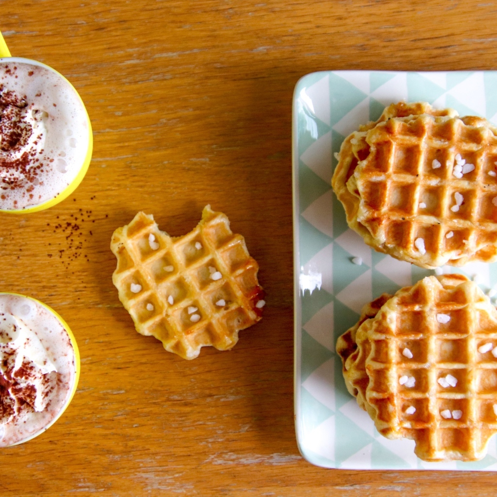 Сладкие вафли на столе с капучино