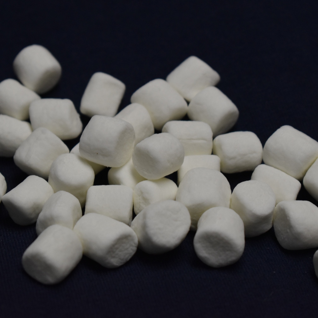 Белое маршмеллоу на черном фоне