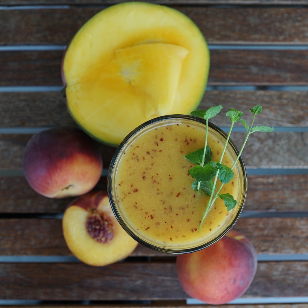 Коктейль с веточкой мяты на столе с фруктами