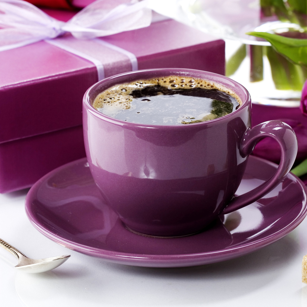 Чашка кофе с подарками и цветами на столе