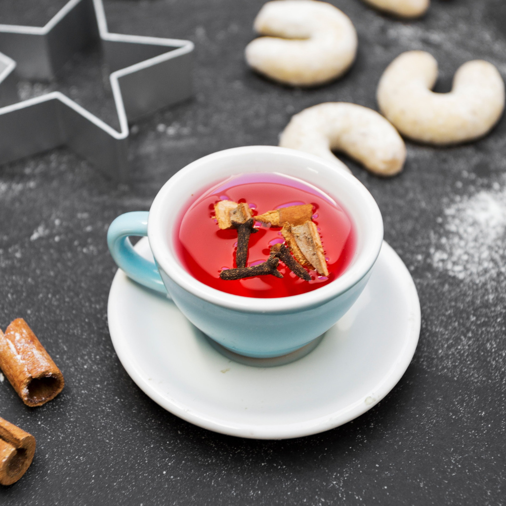 Чашка красного чая на столе с печеньем