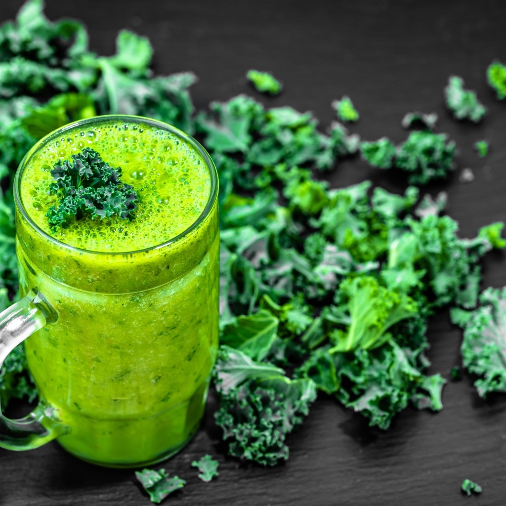Бокал с зеленым смузи с листьями