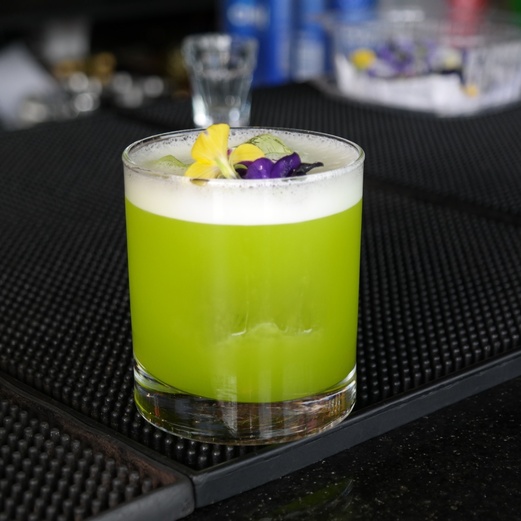 Зеленый коктейль в стакане с цветами