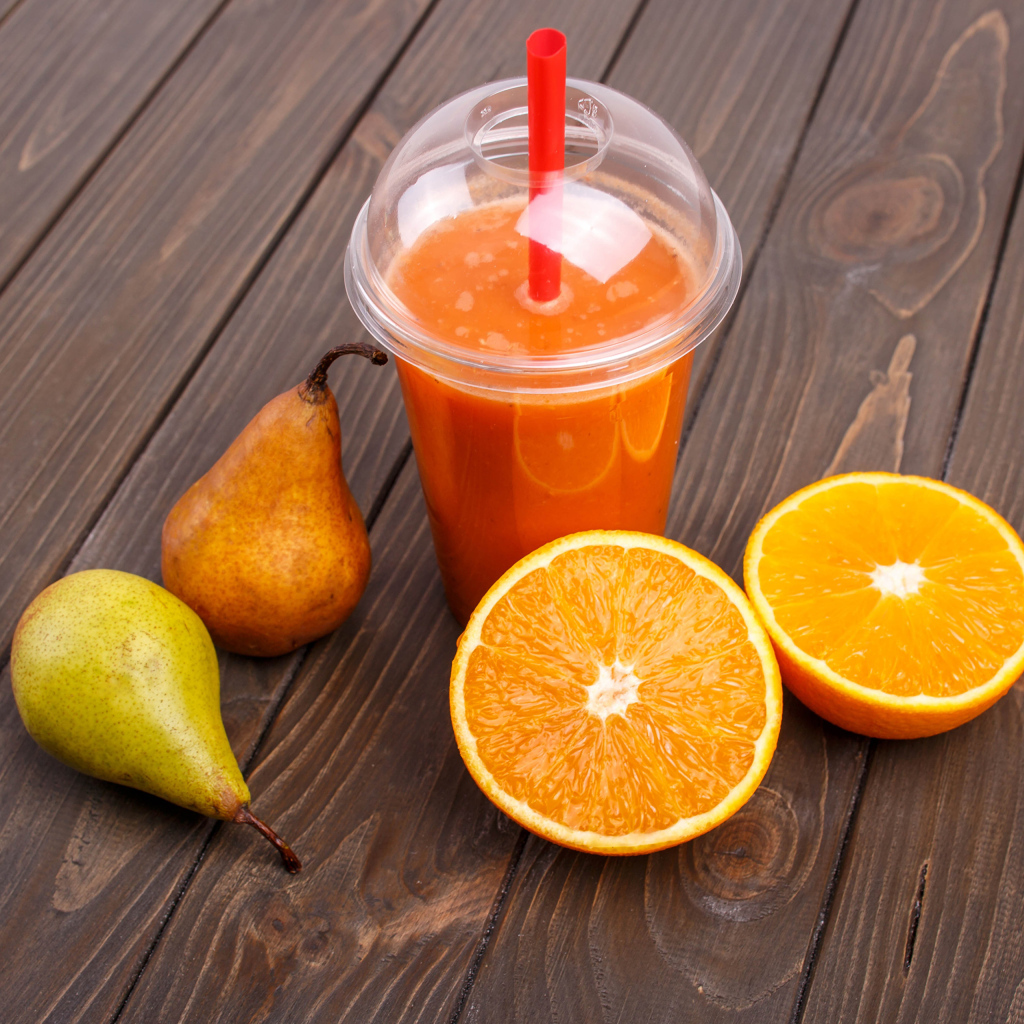 Сок на столе с грушами и апельсином