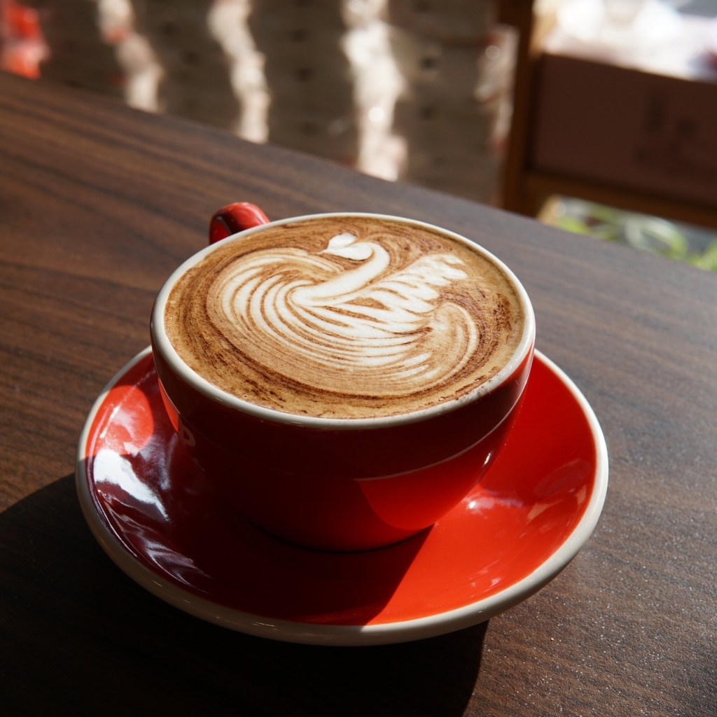 Латте с красивой пенкой в красной чашке