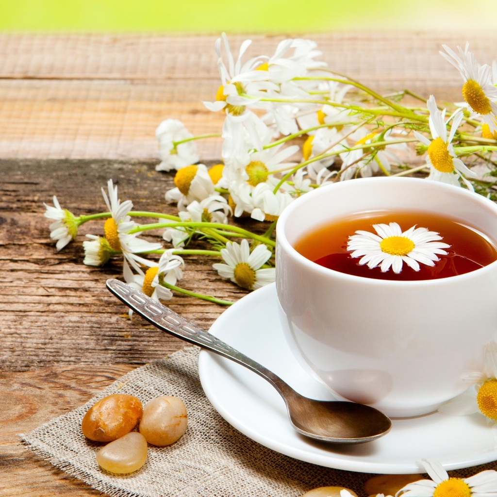 Чай на столе с цветами ромашки и конфетами