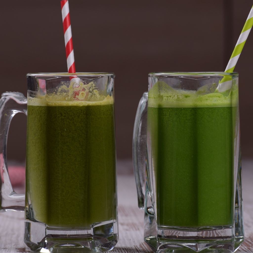 Два стакана зеленого смузи с трубочками