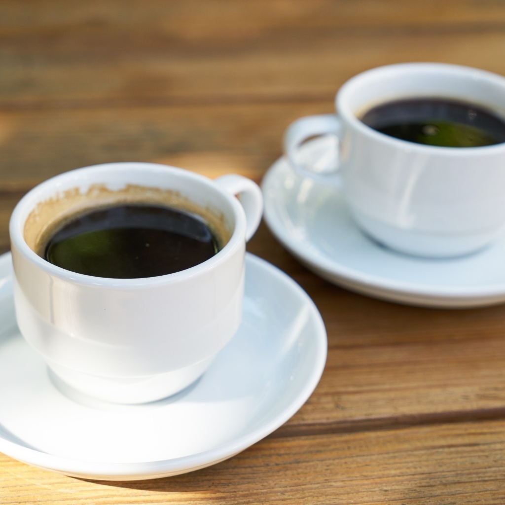 Две белые чашки кофе на столе 