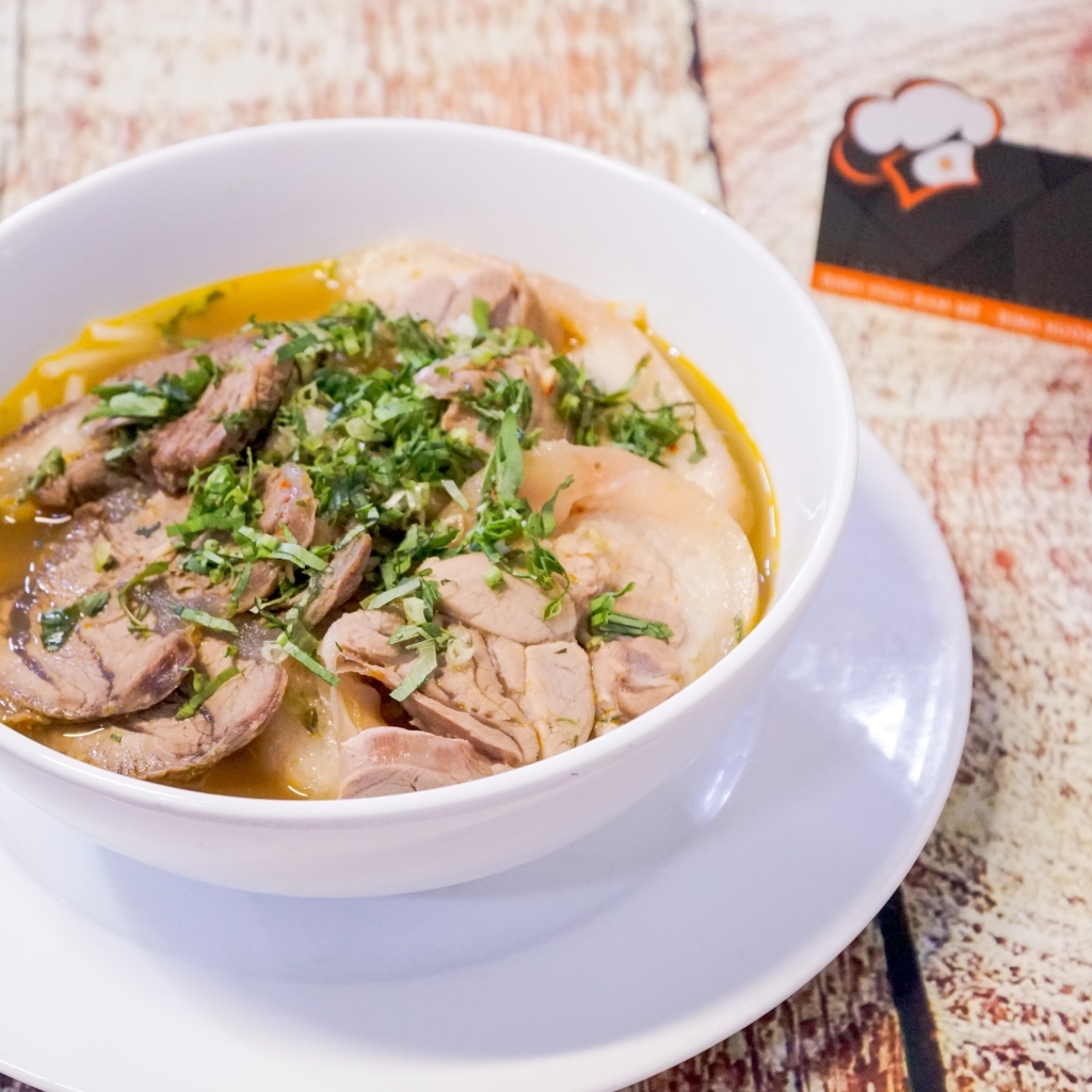 Бульон с мясом в белой тарелке на столе