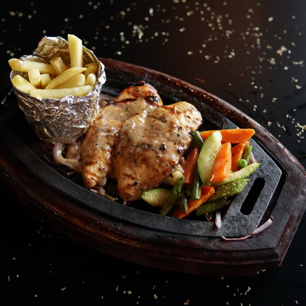 Жареная курица с картофелем фри и салатом на тарелке