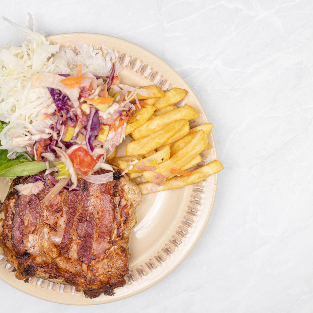 Meat on a plate with french fries and salad
