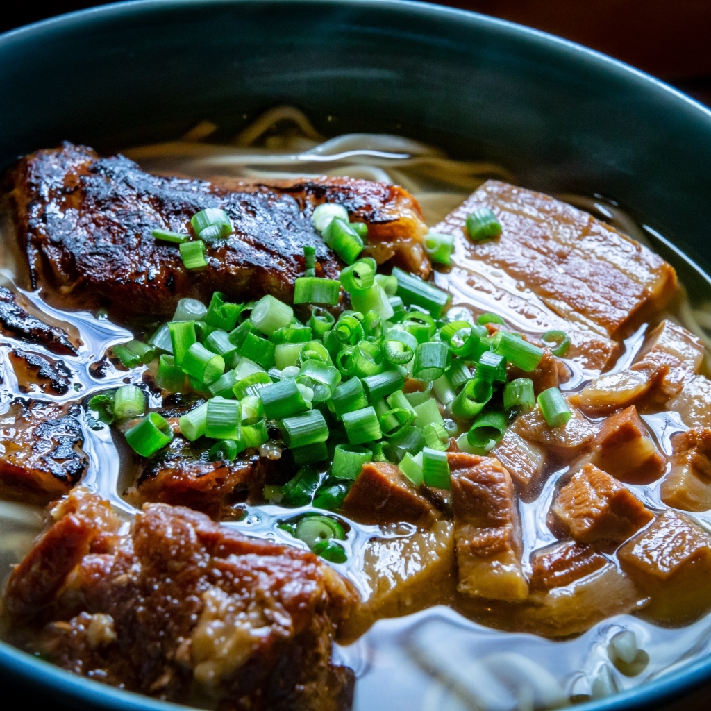 Лапша с мясом и зеленым луком в тарелке