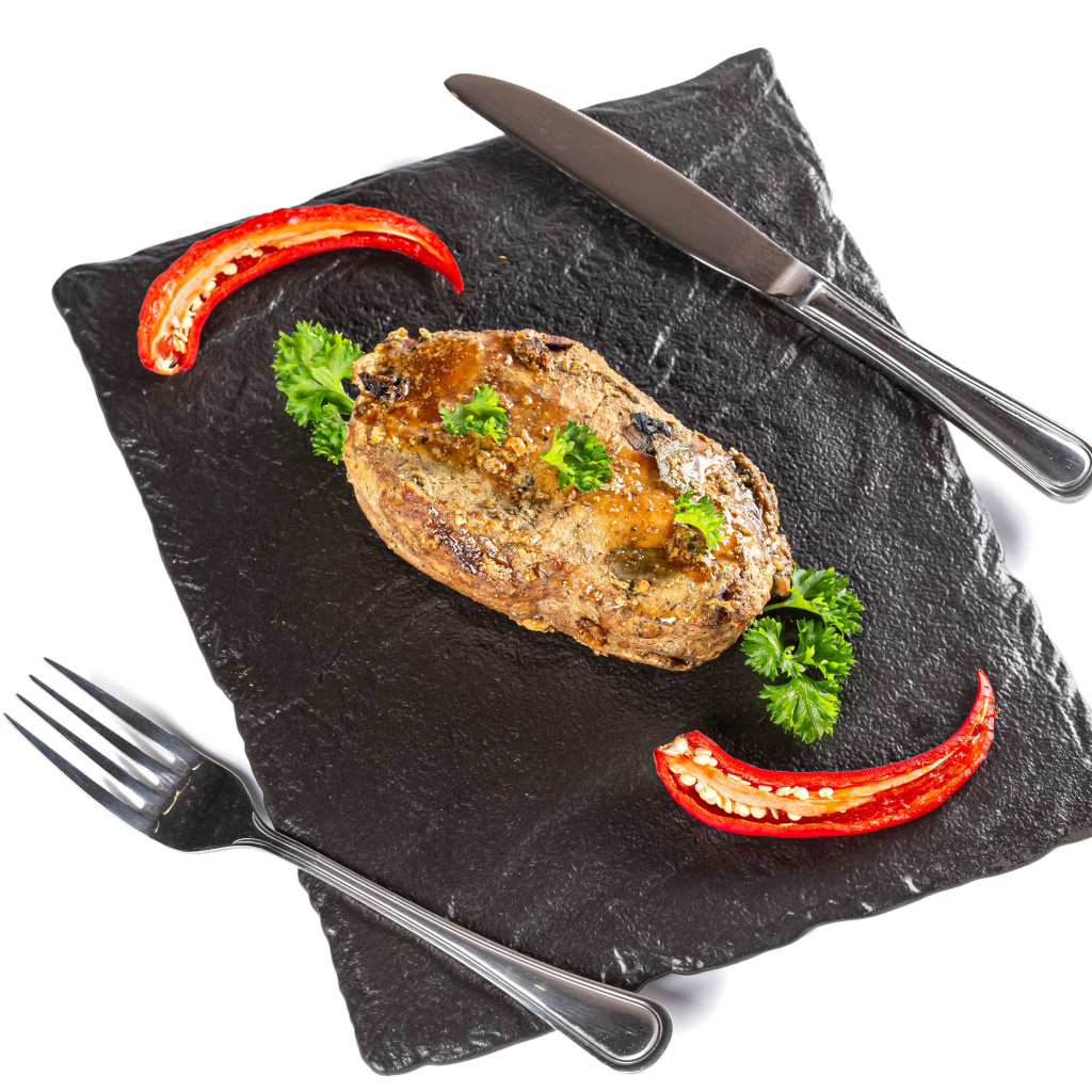 Кусок мяса с красным перцем на доске