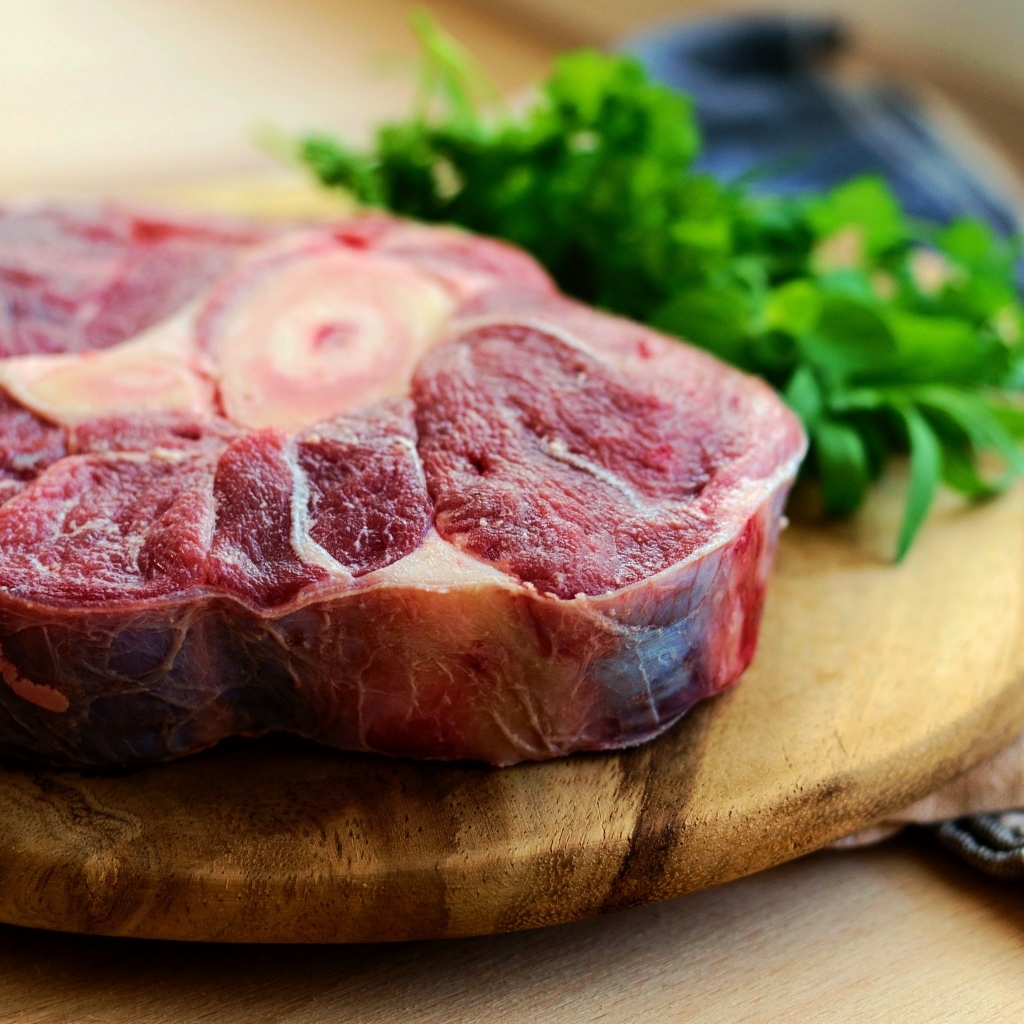 Стейк на деревянной доске с зеленью