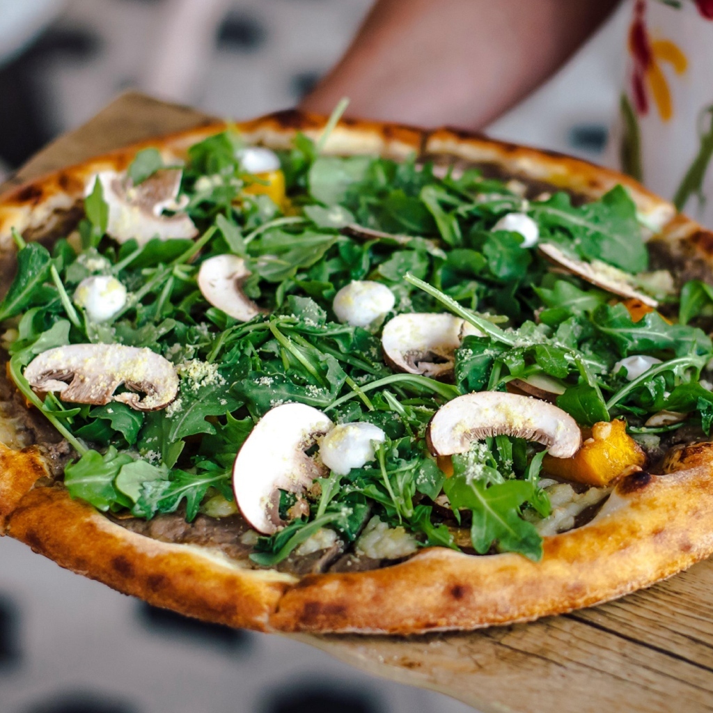 Пицца с грибами и листьями рукколы