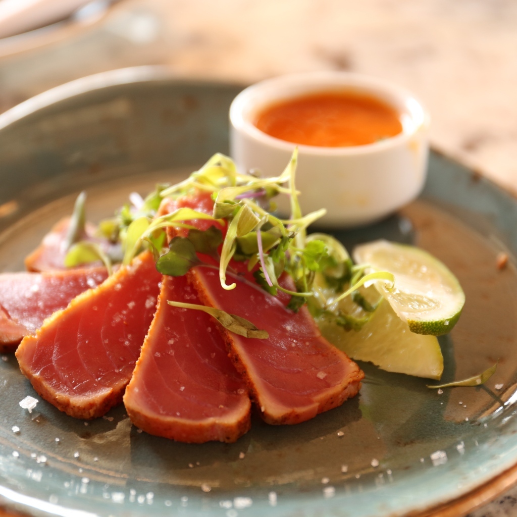 Вяленая красная рыба на тарелке с кусочками лайма