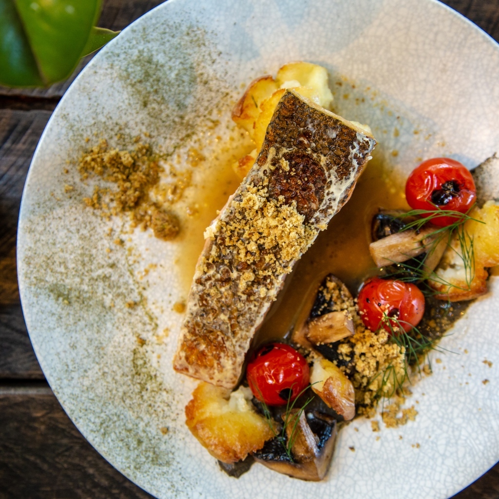 Кусок запеченной рыбы на тарелке с овощами