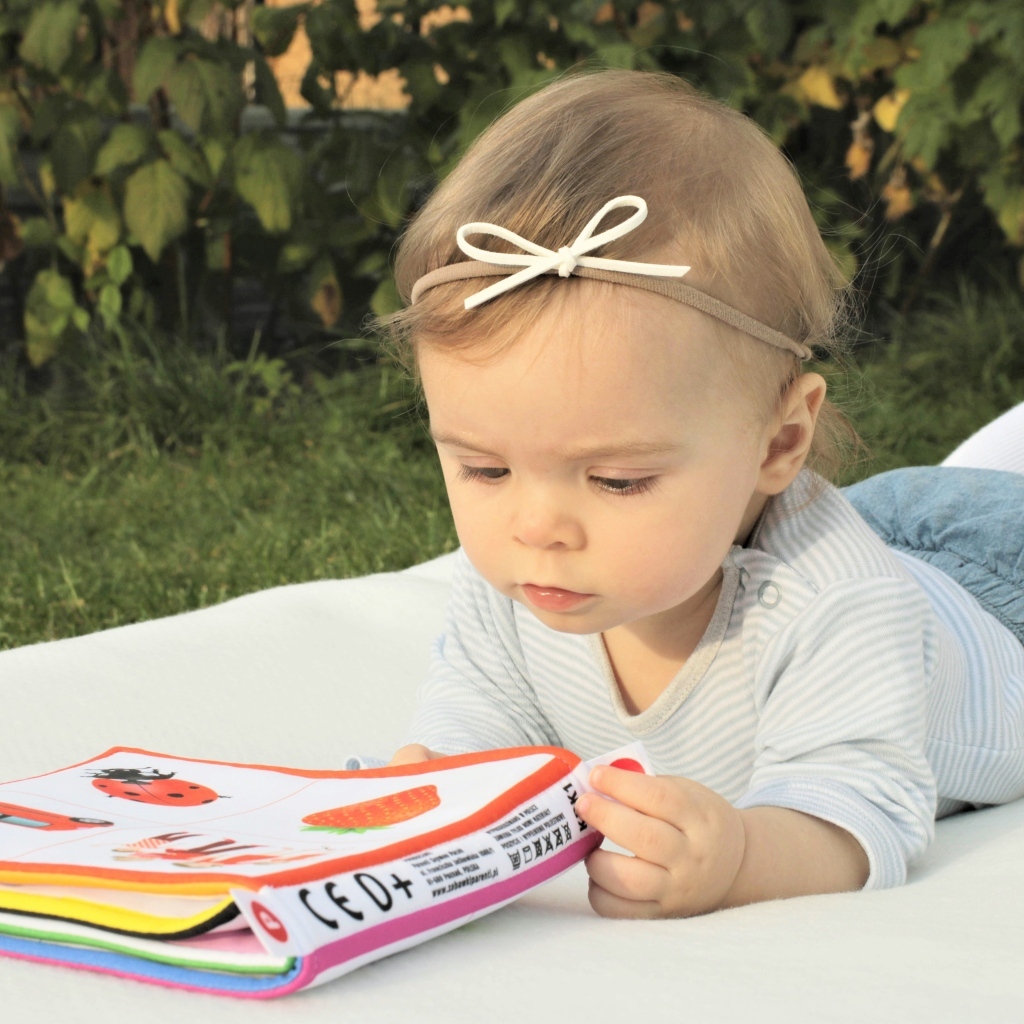 Маленькая девочка с книгой на природе