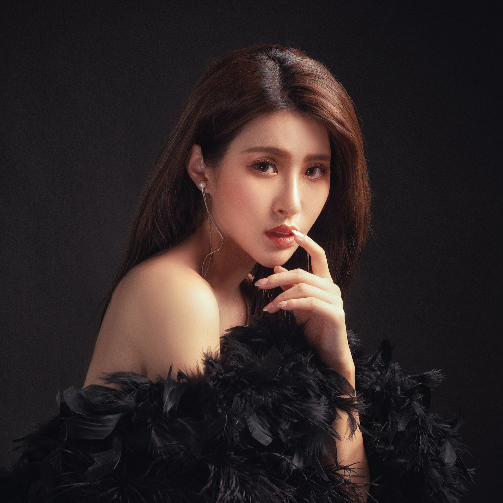 Девушка азиатка в боа на черном фоне