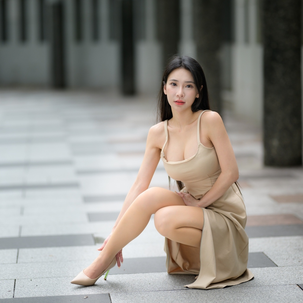 Девушка азиатка в платье сидит на корточках