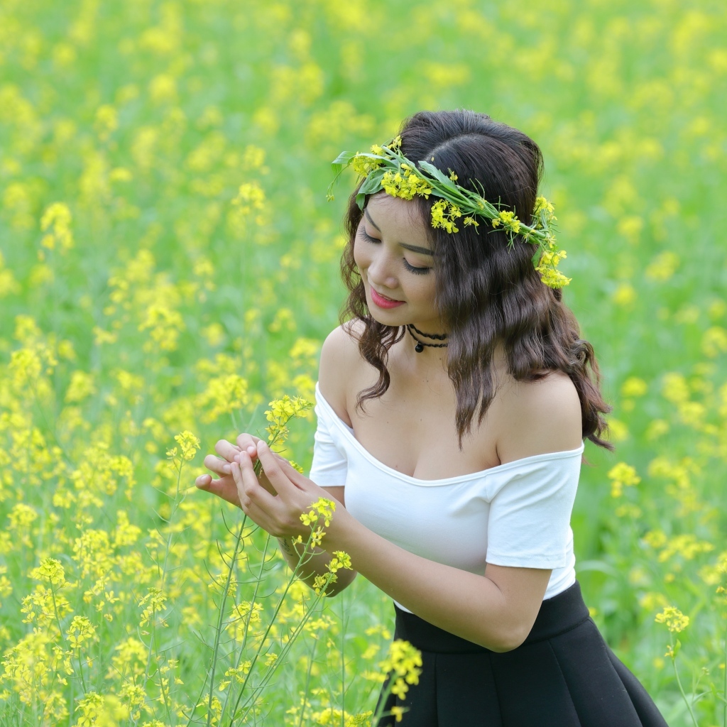 Девушка азиатка на рапсовом поле