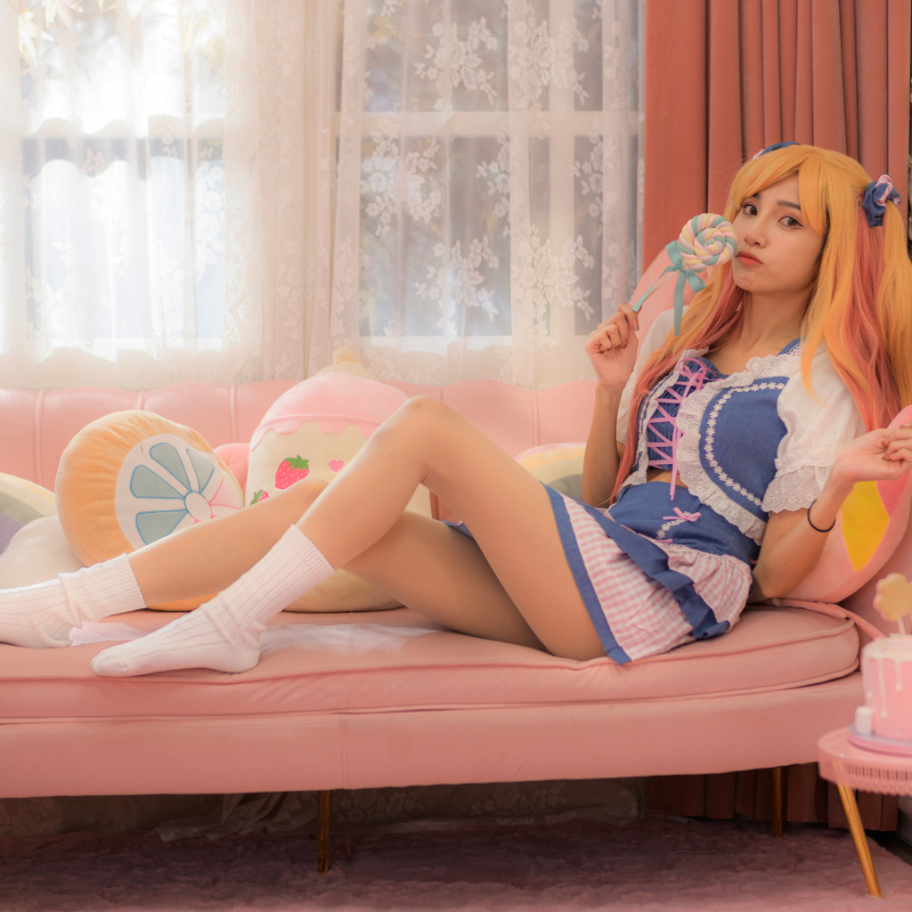 Девушка азиатка в костюме на диване 