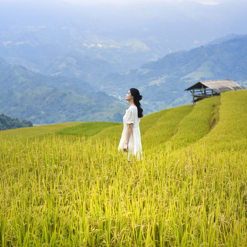 Девушка азиатка в белом платье дышит горным воздухом