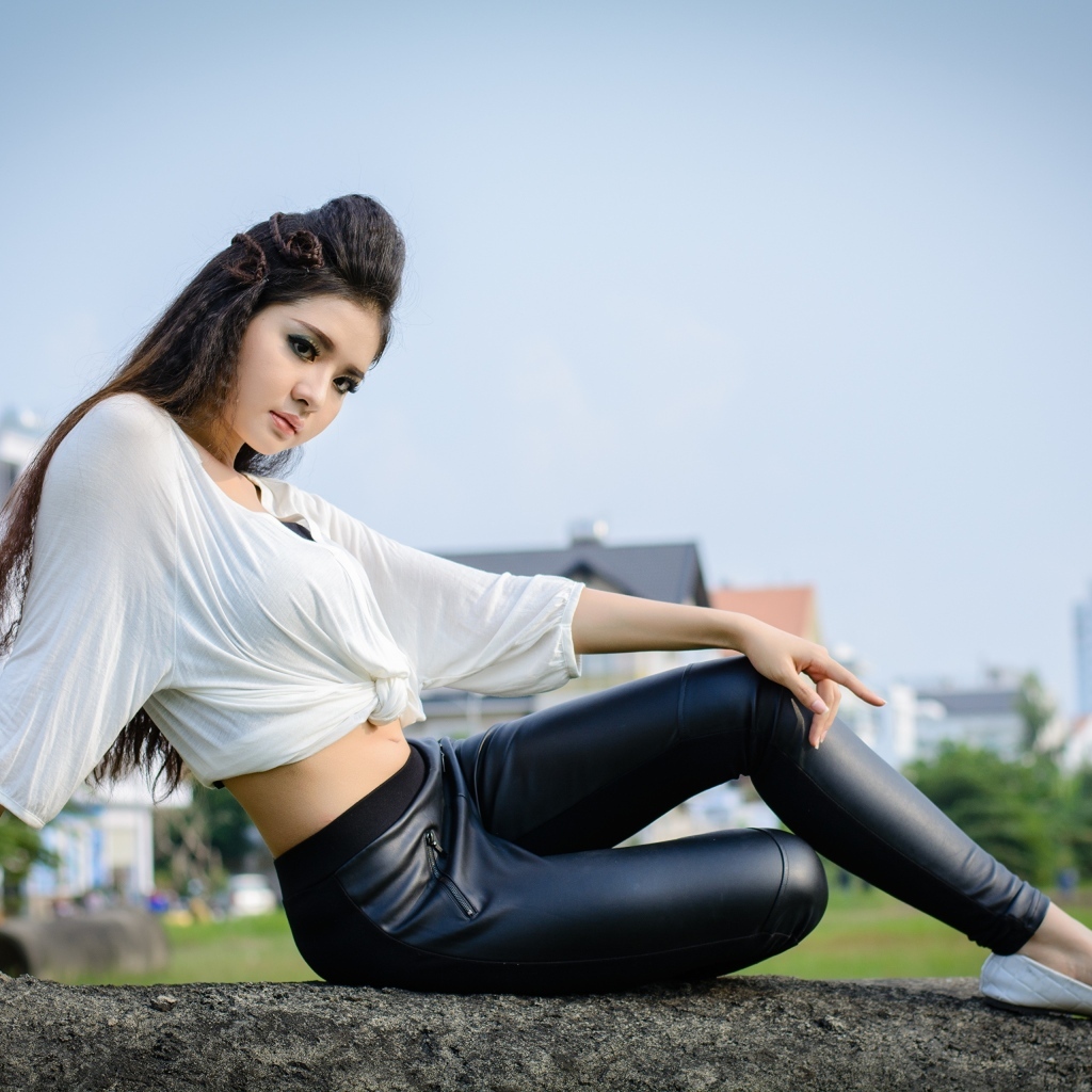 Девушка азиатка в черных кожаных брюках