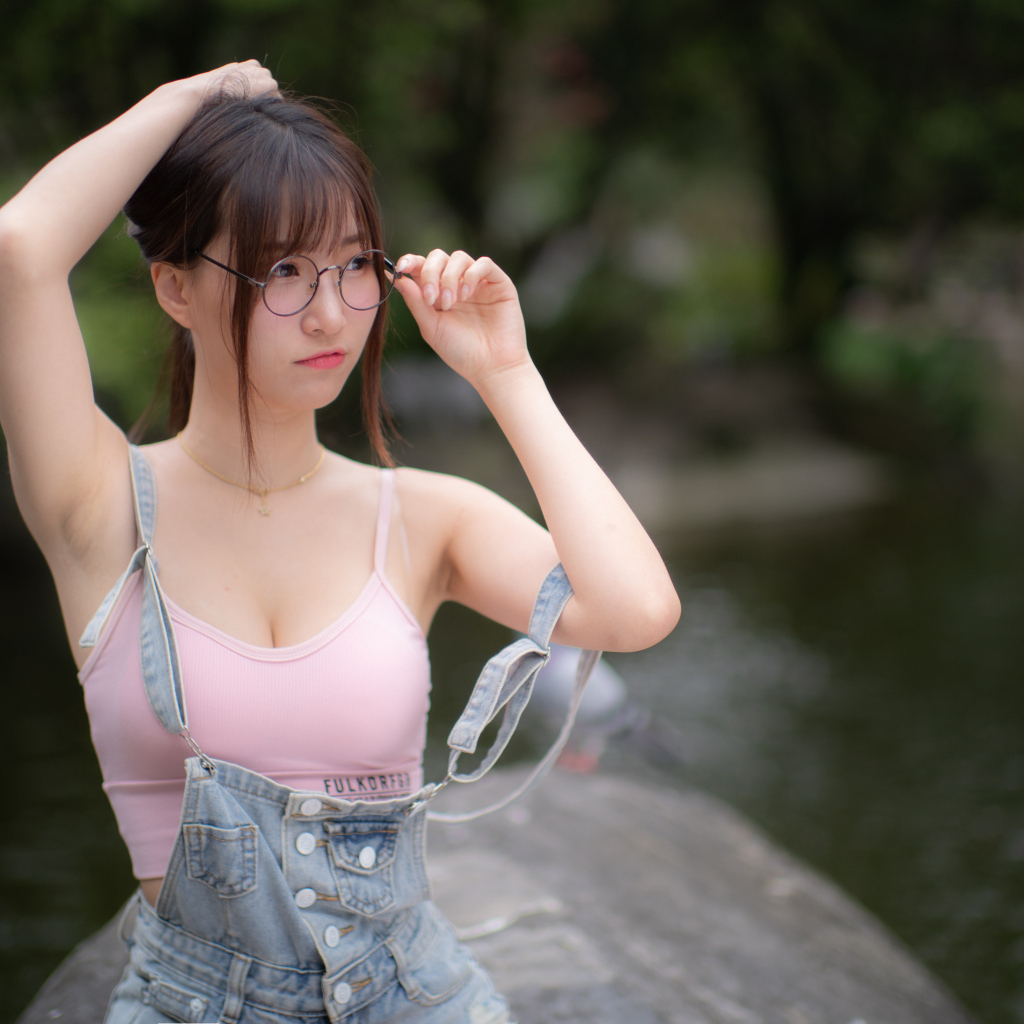 Девушка азиатка в очках и джинсовом комбинезоне