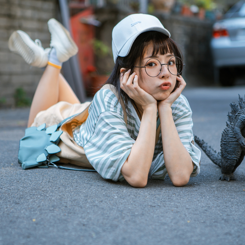 Девушка азиатка с фигуркой годзиллы