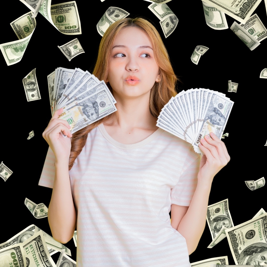 Девушка азиатка с долларами в руках