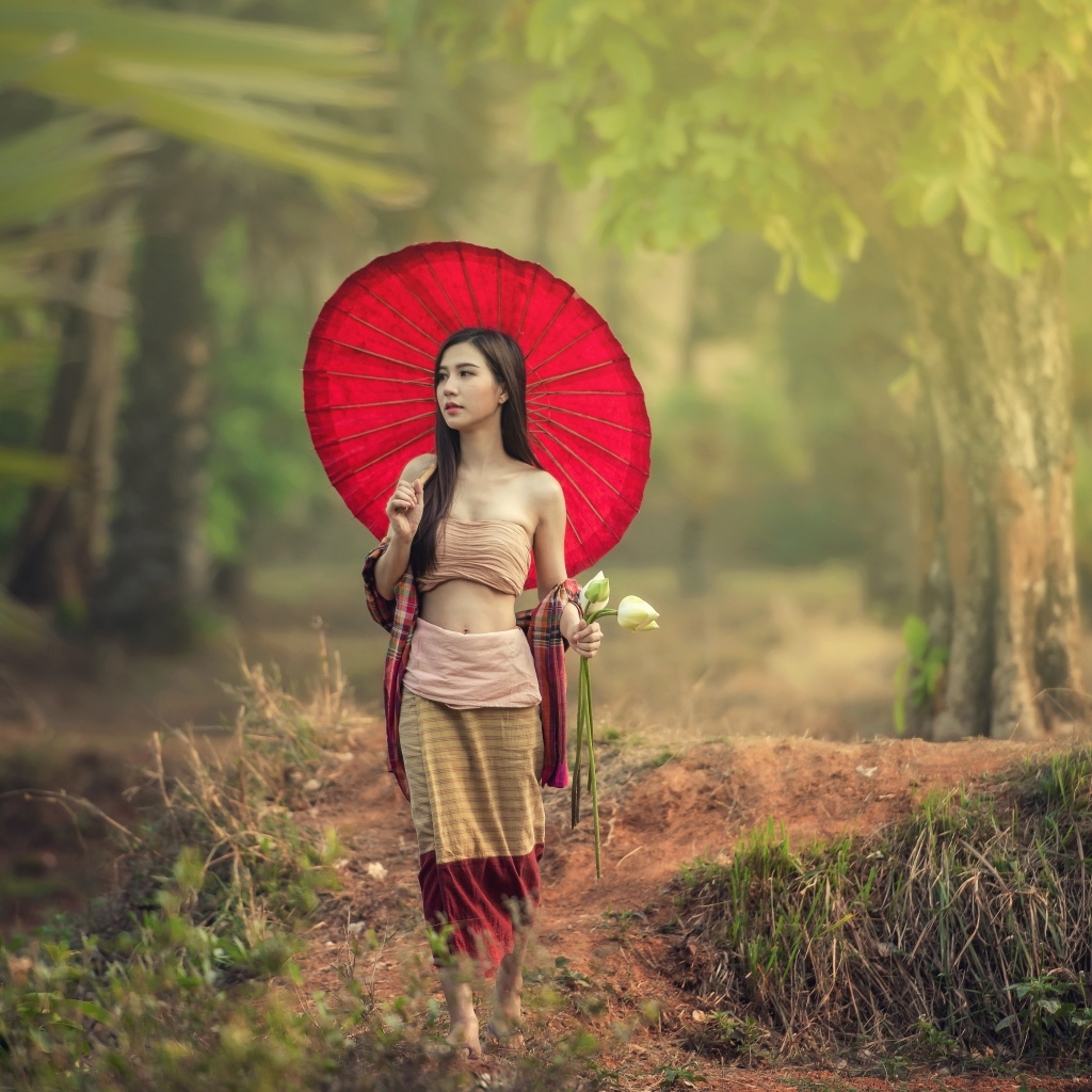Девушка азиатка с красным зонтом и цветами лотоса
