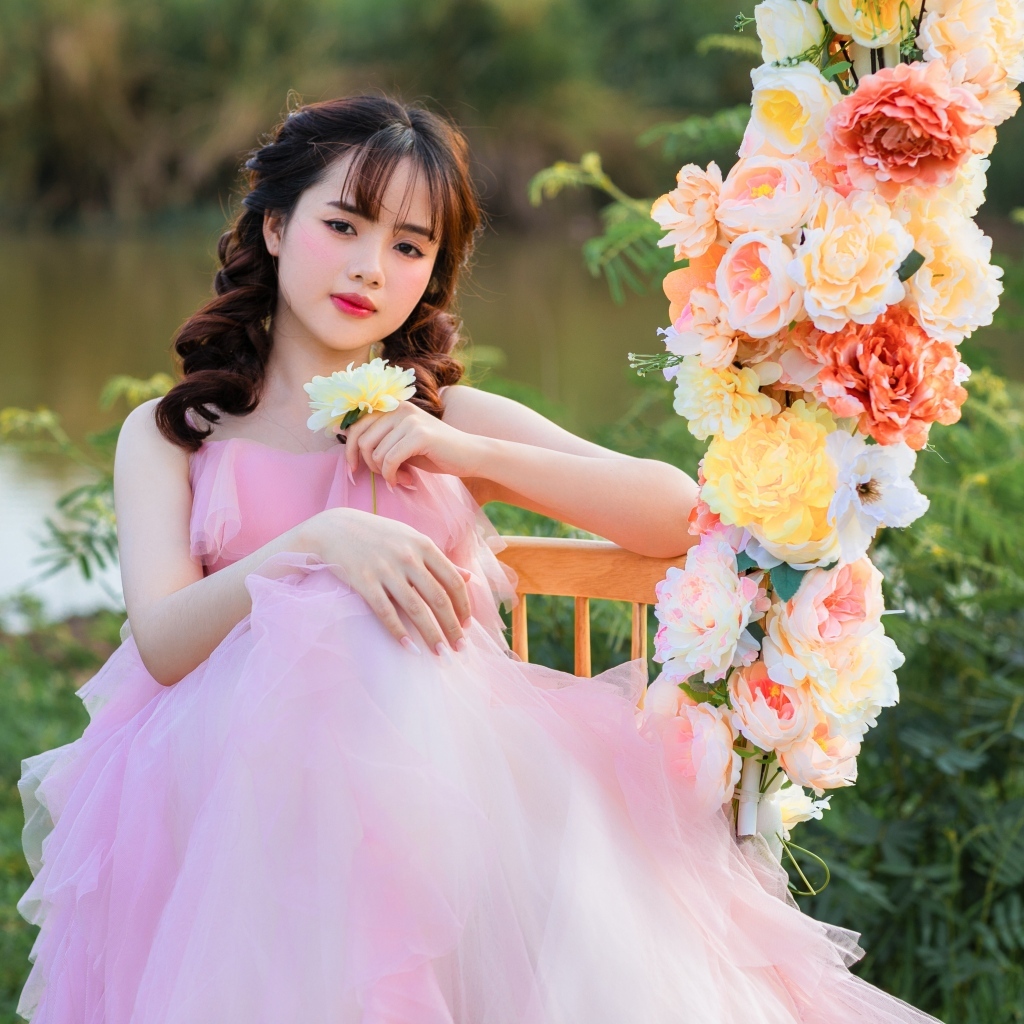 Красивая девушка азиатка в розовом платье с цветами