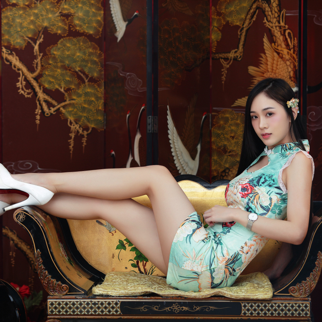 Красивая девушка азиатка лежит на диване