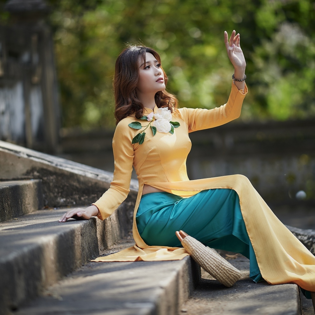 Красивая девушка азиатка сидит на ступеньках