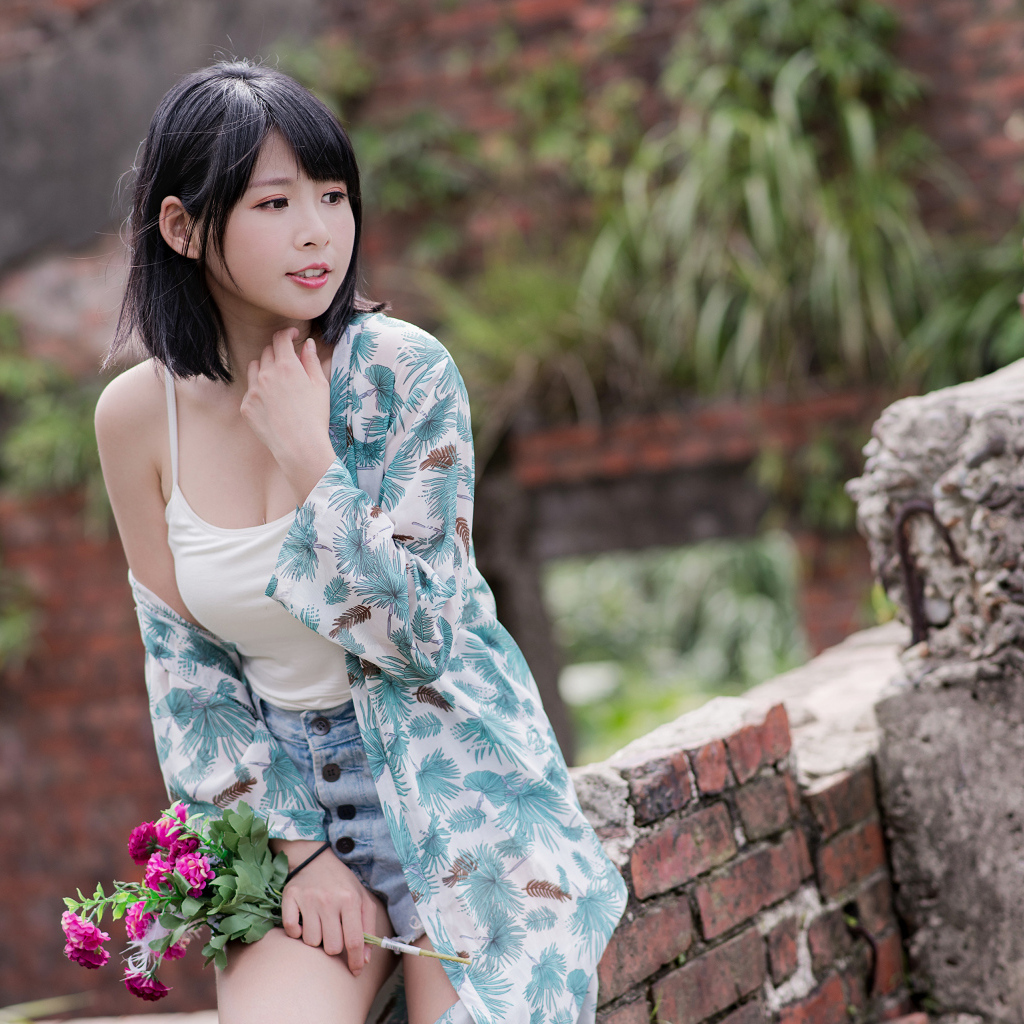 Красивая азиатка с цветком в руке