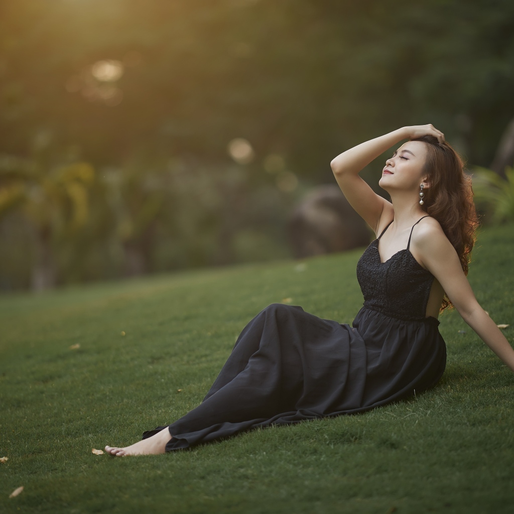 Красивая азиатка с закрытыми глазами в черном платье