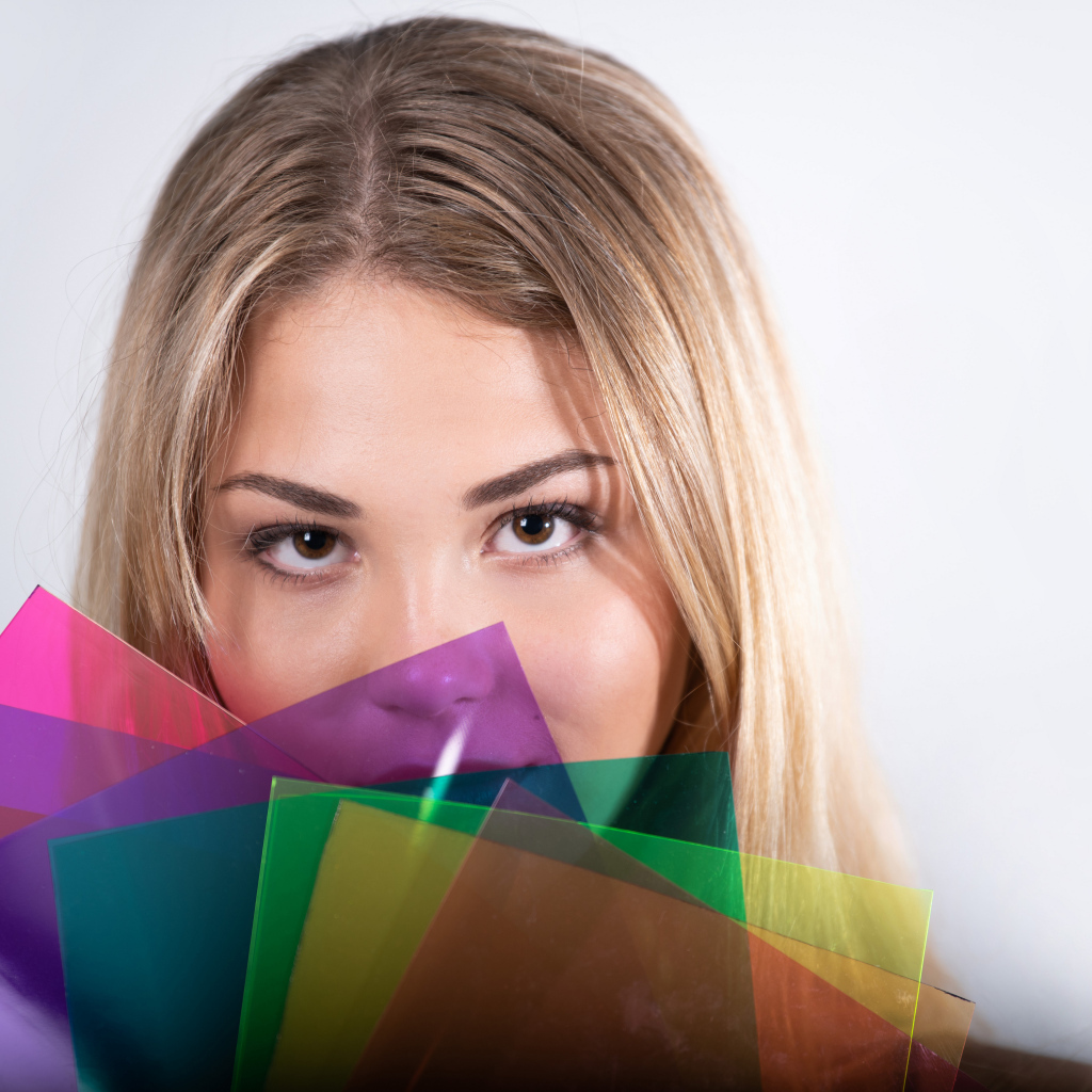 Красивая кареглазая девушка с разноцветной бумагой