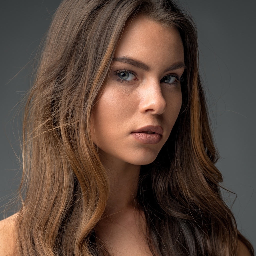 Красивая девушка шатенка на сером фоне 