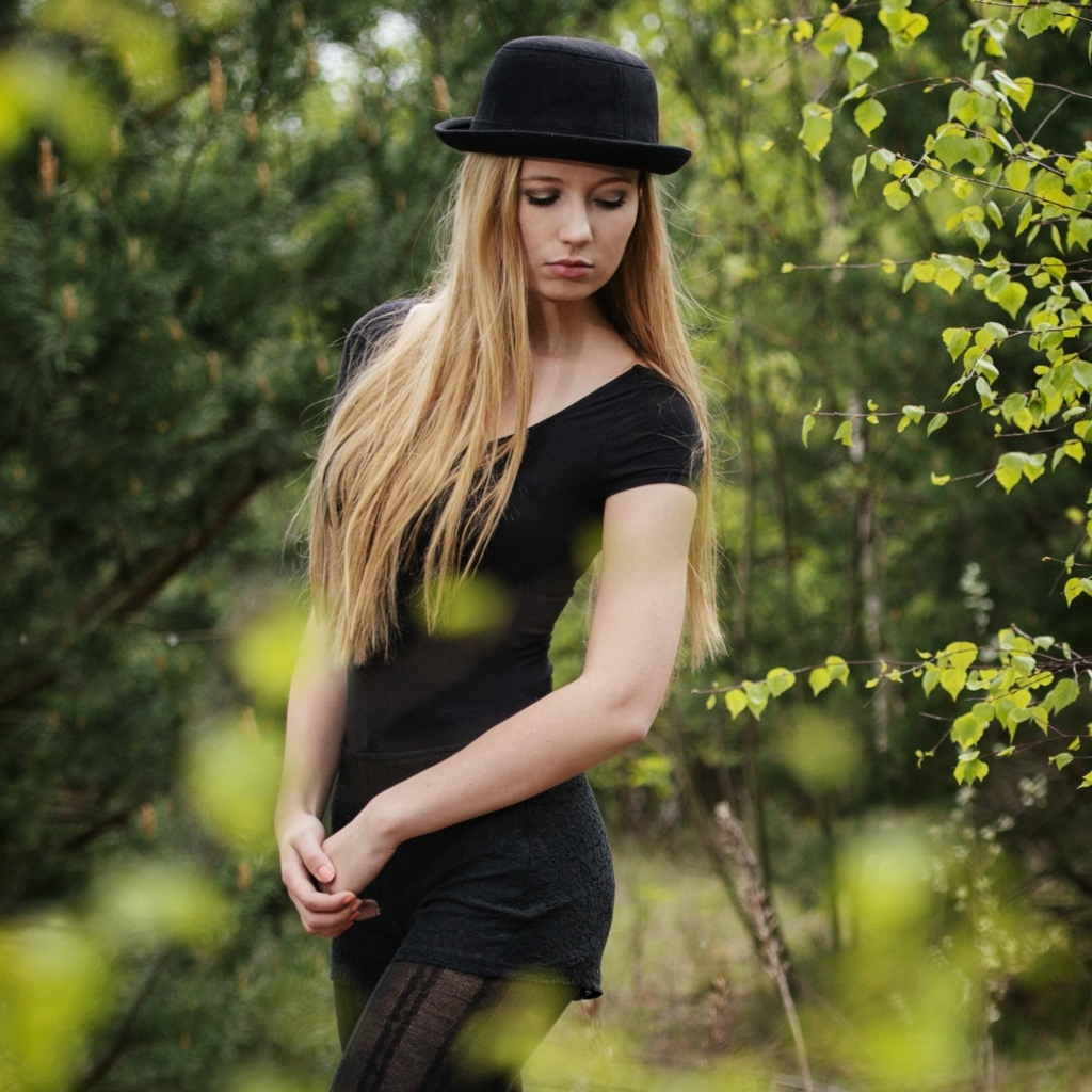Красивая девушка в черном наряде в шляпе