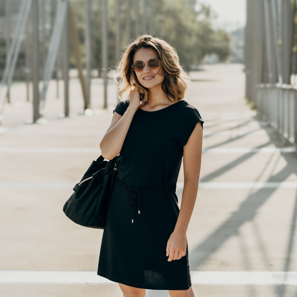 Красивая девушка в черном платье в очках