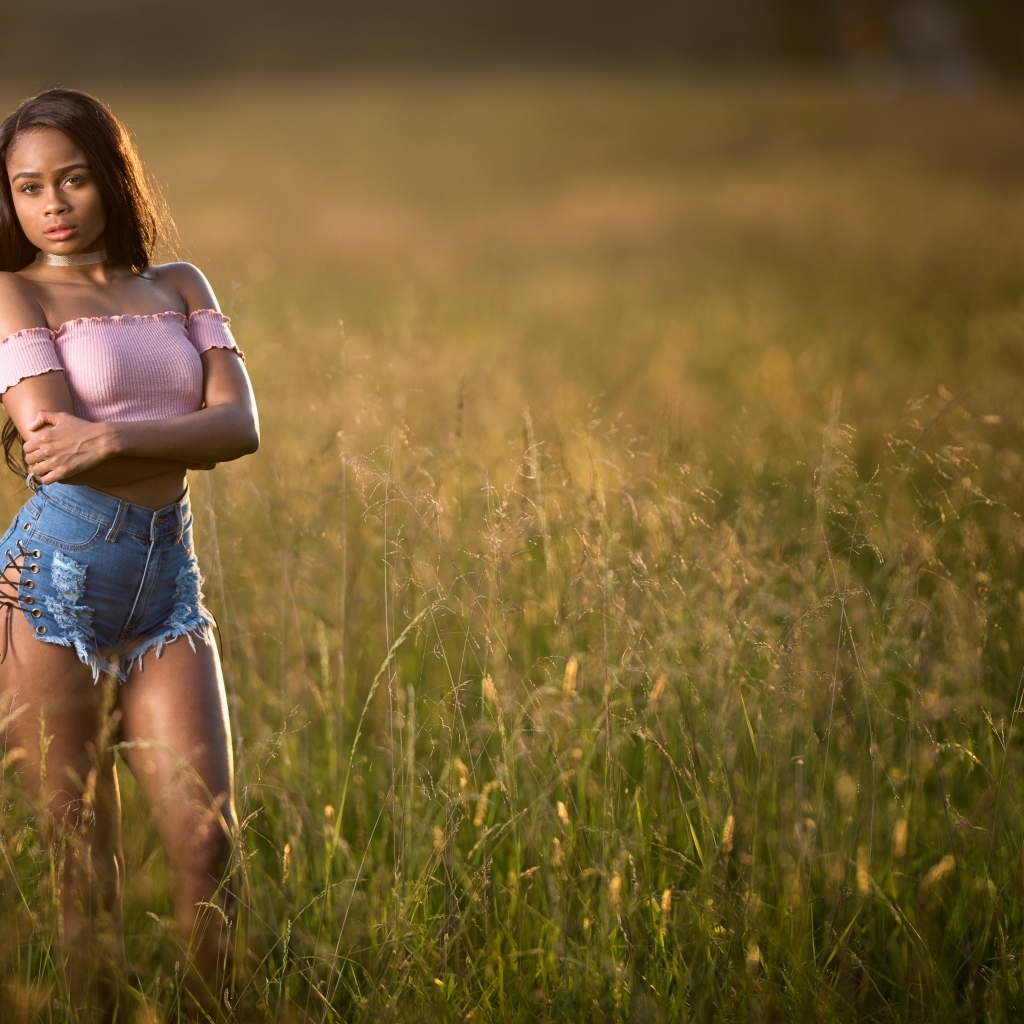 Красивая девушка стоит на поле в траве