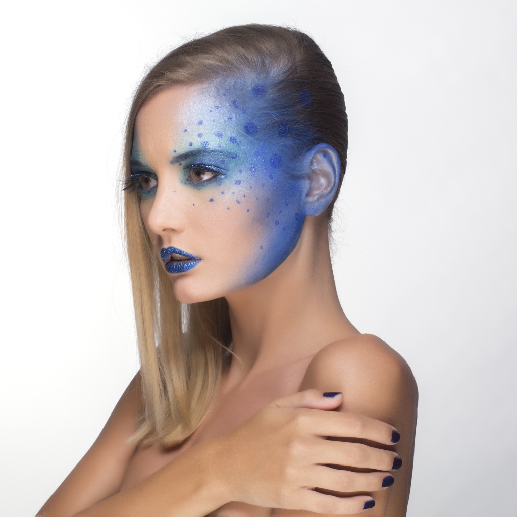 Красивая девушка с синим рисунком на лице