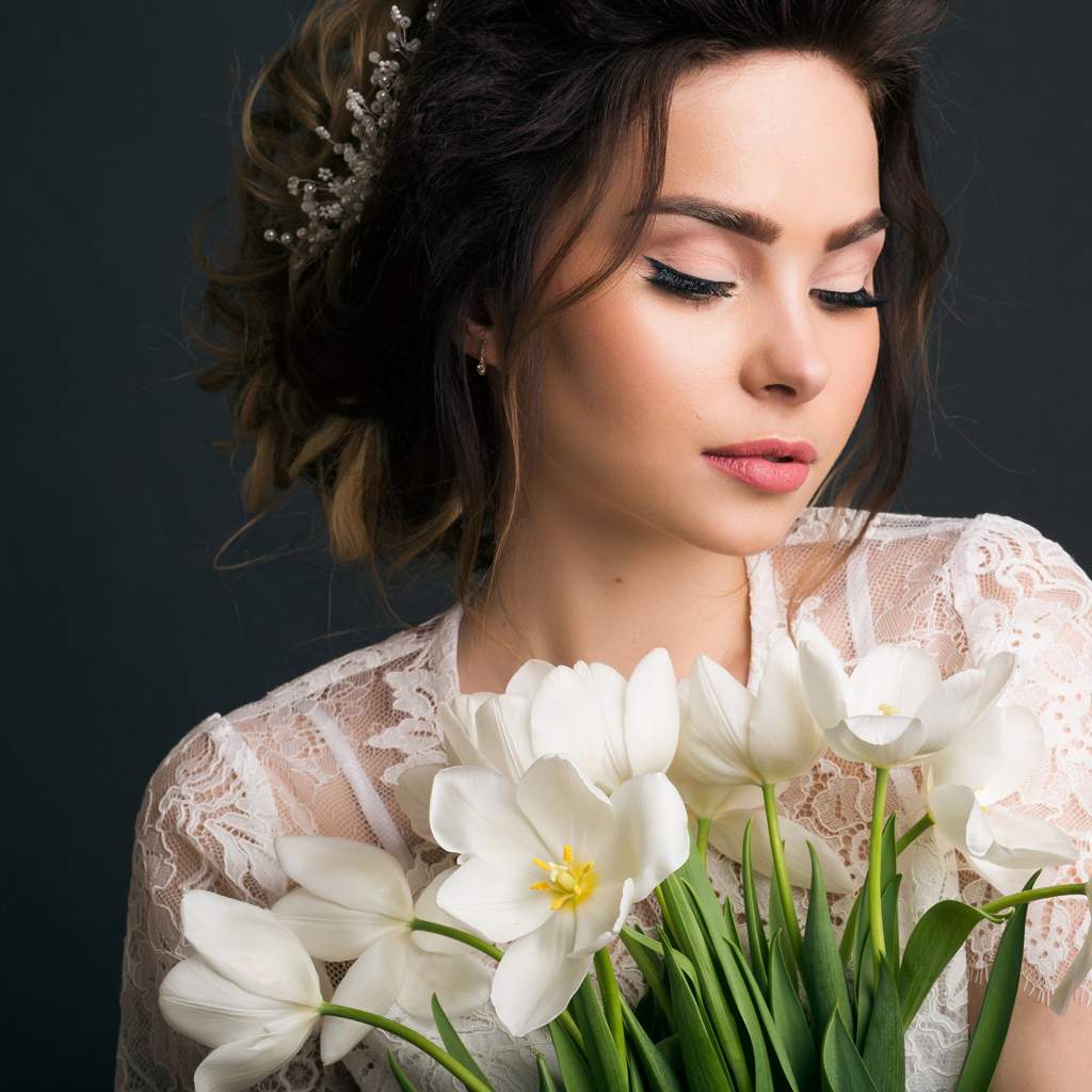 Красивая девушка с букетом белых тюльпанов на сером фоне